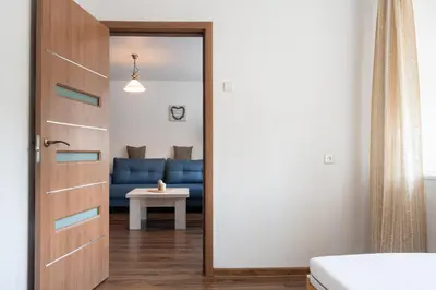 a door leading into a living room with a blue couch at G & M Apartamentai in Anykščiai