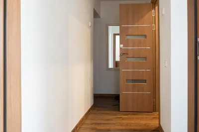 a hallway with a wooden door and a window at G & M Apartamentai in Anykščiai