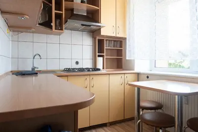 a kitchen with wooden cabinets and a counter top at G & M Apartamentai in Anykščiai