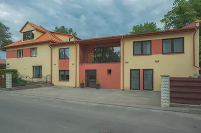 a yellow and orange house on the side of a street at Senasis Nemunas in Druskininkai