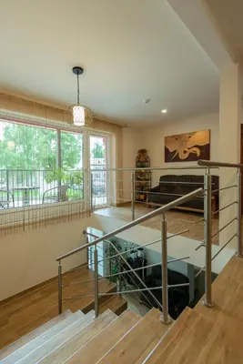 a living room with a staircase in a house at Senasis Nemunas in Druskininkai