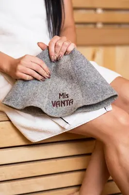 a woman sitting on a bed holding a towel at Green Town in Vievis