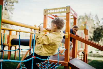a young boy swinging a baseball bat on a playground at Green Town in Vievis