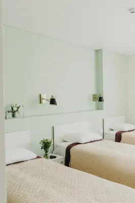 three beds in a room with white walls at Green Town in Vievis