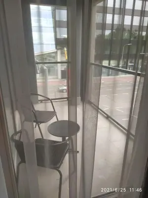 a view of a table and a chair through a window at Urban center apartment in Vilnius