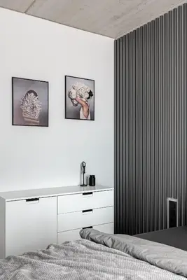 a bedroom with white walls and a bed with white cabinets at Urban center apartment in Vilnius
