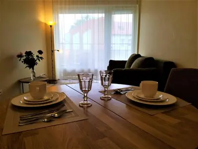 a dining room table with plates and glasses on it at Beautiful Apartment in the heart of Birstonas in Birštonas