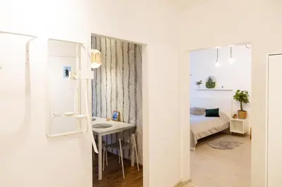 a small room with a bed and a desk and a sink at Visaginas Flat White in Visaginas