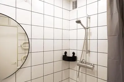 a bathroom with a shower with a mirror at Visaginas Flat White in Visaginas