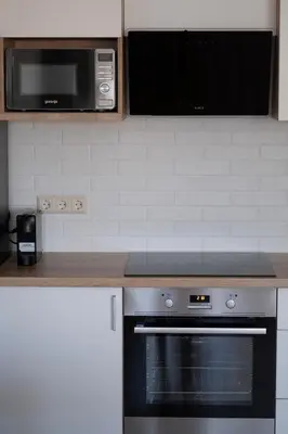 a kitchen with a stove and a microwave at Amazing Snow Apartments in Druskininkai