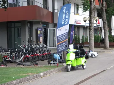 a green scooter parked next to a row of bikes at Amazing Snow Apartments in Druskininkai