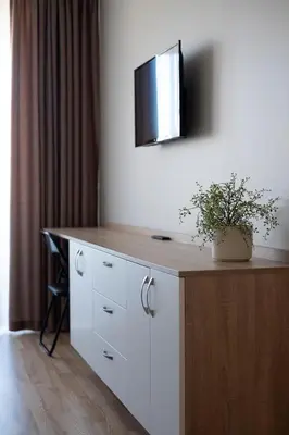 a room with a desk with a tv on the wall at Amazing Snow Apartments in Druskininkai