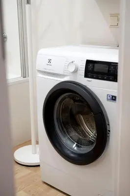 a white washing machine sitting next to a window at Amazing Snow Apartments in Druskininkai
