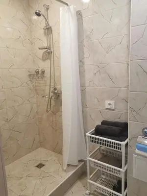 a bathroom with a shower with a shower curtain at Upės apartamentai in Biržai