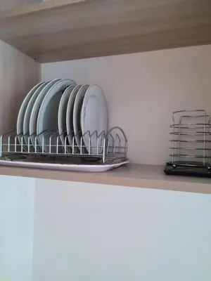 a shelf with plates and dishes on it at Upės apartamentai in Biržai