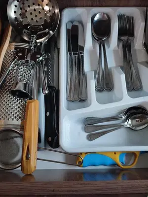 a drawer filled with utensils on a shelf at Upės apartamentai in Biržai