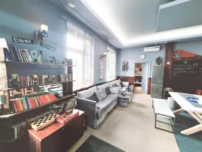 a living room with a couch and a shelf of books at HelloVilniusHostel in Vilnius