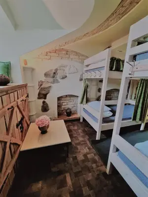 a room with two bunk beds and a fireplace at HelloVilniusHostel in Vilnius