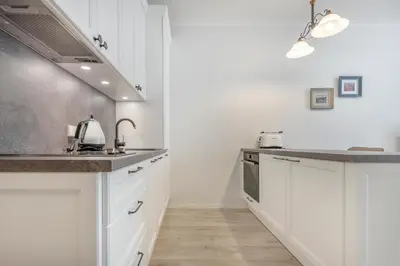 a kitchen with white cabinets and a sink at HaPPy Inn Rich Studio, Self Check-In-24x7,Parking-in-the-underground-Garage in Vilnius