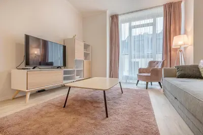 a living room with a couch and a tv at HaPPy Inn Rich Studio, Self Check-In-24x7,Parking-in-the-underground-Garage in Vilnius