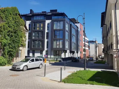 a car parked in a parking lot in front of a building at HaPPy Inn Rich Studio, Self Check-In-24x7,Parking-in-the-underground-Garage in Vilnius