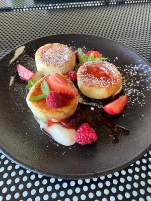 a plate with donuts and strawberries on a table at Wakepond atostogų slėnis in Anykščiai