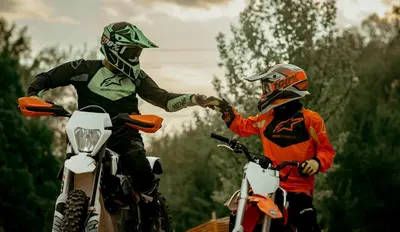two people on motorcycles shaking hands with each other at Wakepond atostogų slėnis in Anykščiai
