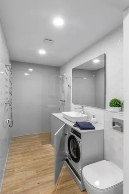 a bathroom with a washing machine and a sink at Brand new apartment in Vilnius in Vilnius