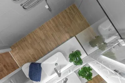 a bathroom with a toilet and a sink and two plants at Brand new apartment in Vilnius in Vilnius