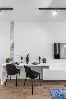 a white living room with two chairs and a table at Brand new apartment in Vilnius in Vilnius