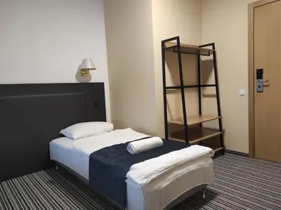 a hotel room with a bed and a shelf at B&B Panevėžys in Panevėžys