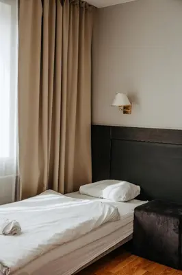 a bedroom with a bed and a window with curtains at B&B Panevėžys in Panevėžys