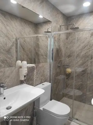 a bathroom with a shower and a toilet and a sink at B&B Panevėžys in Panevėžys
