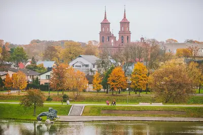 a park with a fountain and a church in the background at B&B Panevėžys in Panevėžys