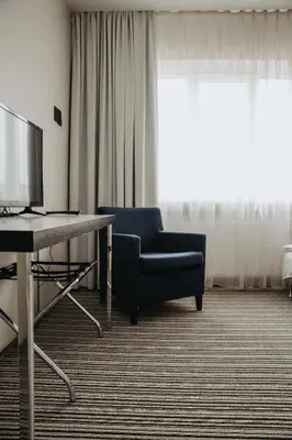 a living room with a chair and a television at B&B Panevėžys in Panevėžys
