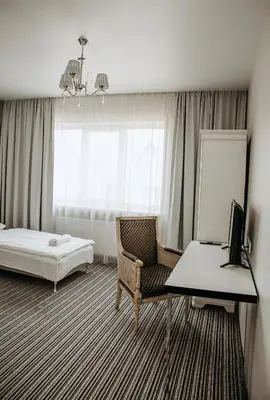 a hotel room with a bed and a desk and a chair at B&B Panevėžys in Panevėžys