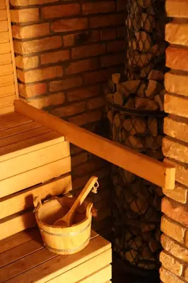 a bucket sitting on a shelf next to a fireplace at Poilsio namas Vydautiškių slėnis in Sudervė