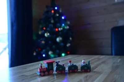 a toy train on a table in front of a christmas tree at Poilsio namas Vydautiškių slėnis in Sudervė