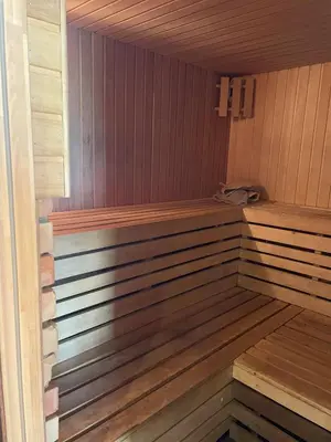 a wooden sauna with a wooden bench in it at Gintaro pirtelė in Lazdijai