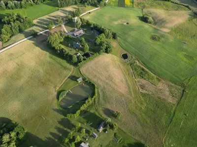 an overhead view of a field with houses and trees at Gintaro pirtelė in Lazdijai