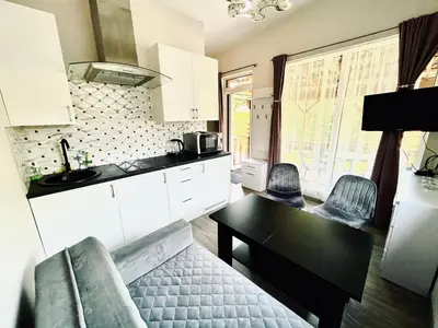 a kitchen with a black table and chairs in a room at Royal Resident in Druskininkai