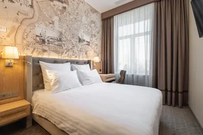 a hotel room with a bed and a large window at CALVARY Hotel & Restaurant Vilnius in Vilnius