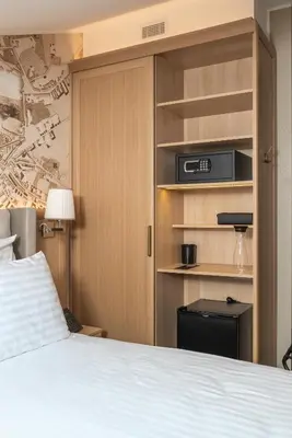 a bedroom with a bed and a book shelf at CALVARY Hotel & Restaurant Vilnius in Vilnius