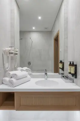 a white bathroom with a sink and a shower at CALVARY Hotel & Restaurant Vilnius in Vilnius