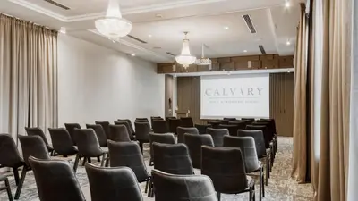 a conference room with chairs and a projection screen at CALVARY Hotel & Restaurant Vilnius in Vilnius
