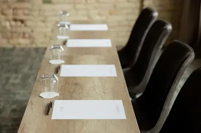 a long table with wine glasses and envelopes on it at CALVARY Hotel & Restaurant Vilnius in Vilnius
