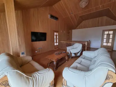a living room with two white couches and a tv at Villa MAG in Druskininkai