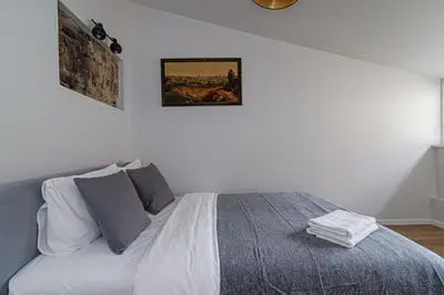 a bedroom with a bed with a painting on the wall at Zydu str two bedrooms Apartment by URBAN RENT in Vilnius