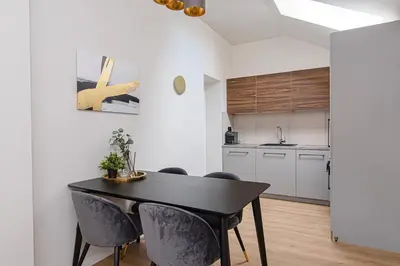 a kitchen and dining room with a black table and chairs at Zydu str two bedrooms Apartment by URBAN RENT in Vilnius