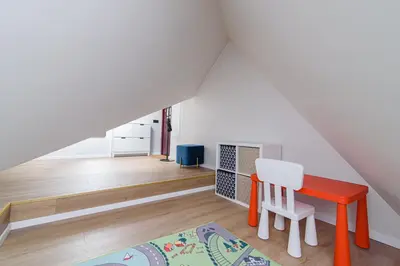 a room with a table and a chair in a attic at Zydu str two bedrooms Apartment by URBAN RENT in Vilnius